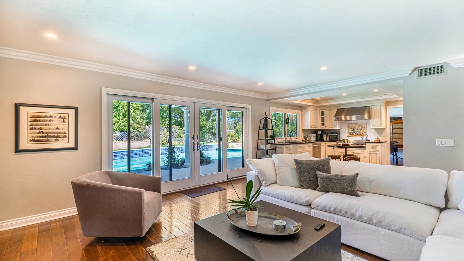 Bright living room with a wall of sliding glass doors facing a backyard pool
