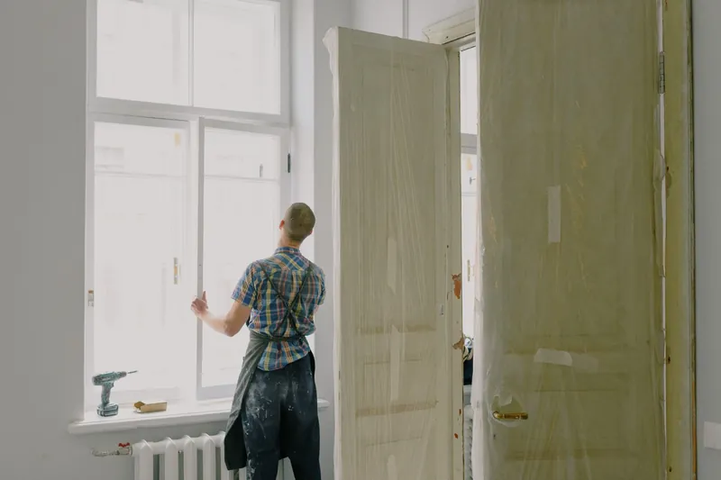 Contractor working on a window installation in a bright room