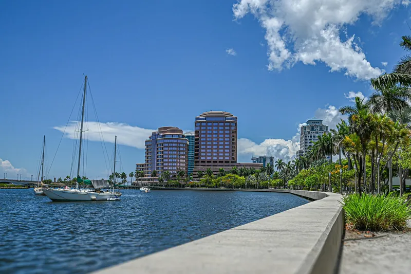 Sailboat on the Intracoastal Waterway with palm trees along the seawall in Palm Beach County