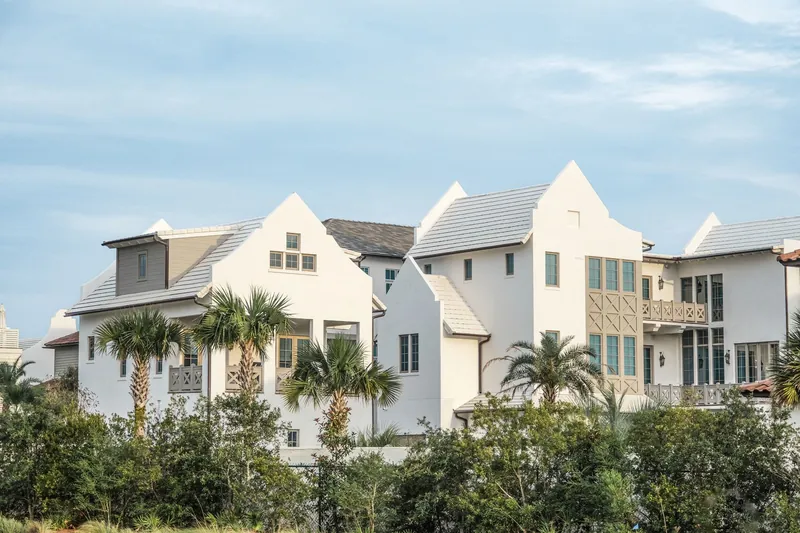 Newer white homes with palm trees and landscaping