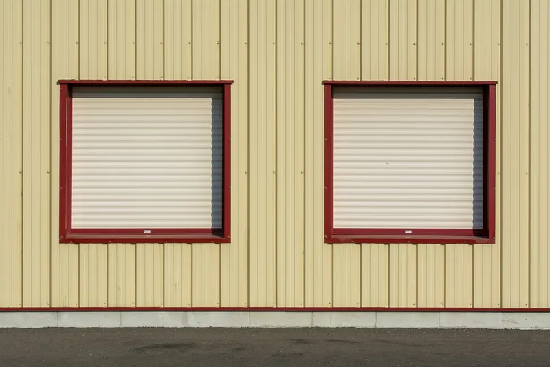 Two windows with closed roll-down shutters